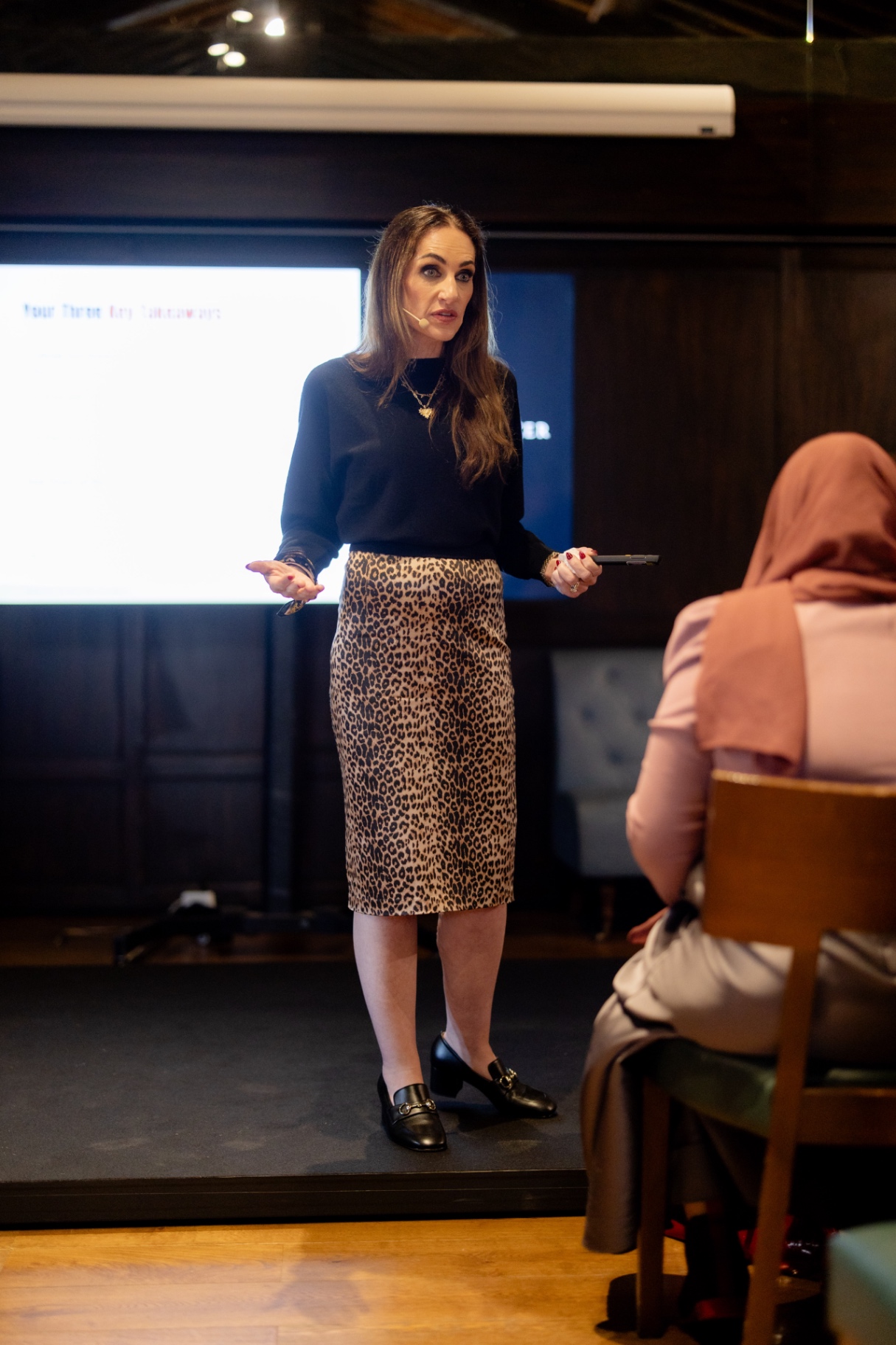 Aleesha Webb on stage presenting key takeaways